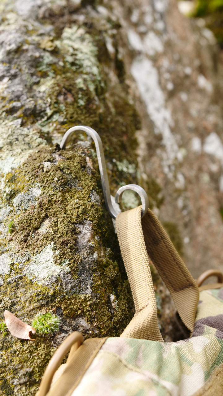 barqHook gripping a mossy rock while holding a pack strap